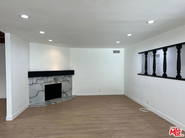 unfurnished living room with hardwood / wood-style flooring and a premium fireplace