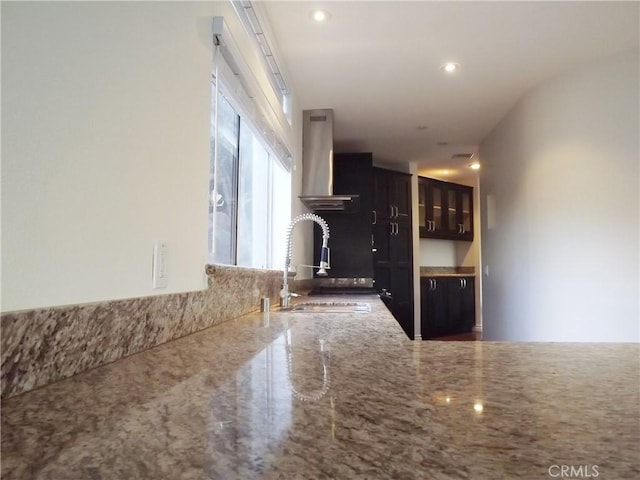 kitchen with extractor fan, light stone countertops, and sink