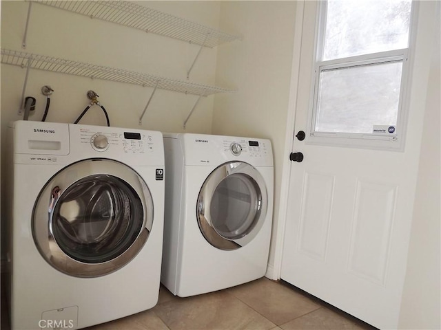 laundry room with independent washer and dryer and light tile patterned flooring