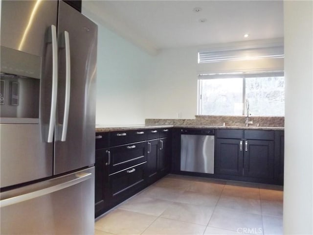 kitchen with light stone countertops, sink, appliances with stainless steel finishes, and light tile patterned flooring