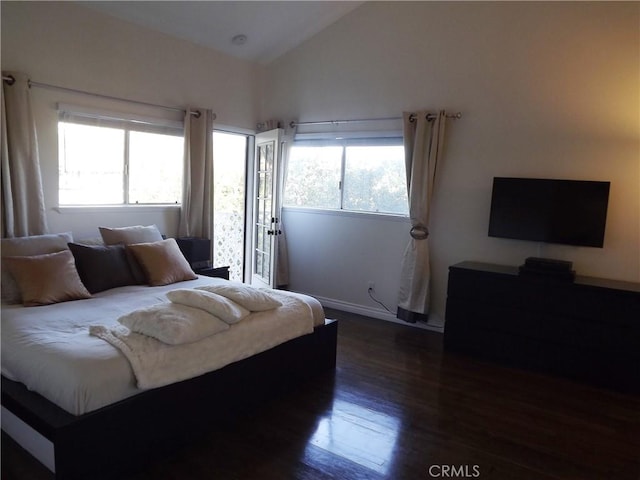 bedroom featuring dark hardwood / wood-style flooring, lofted ceiling, and multiple windows