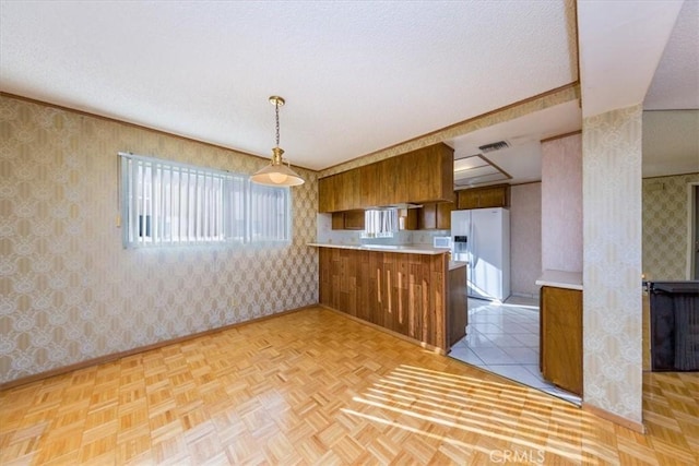 kitchen featuring decorative light fixtures, light parquet flooring, kitchen peninsula, and white refrigerator with ice dispenser