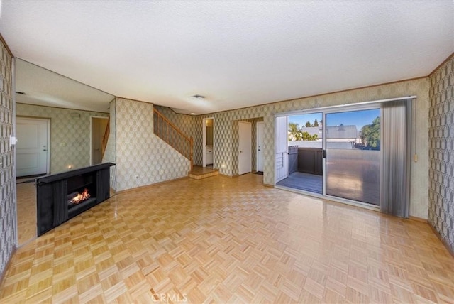 unfurnished living room with parquet flooring and a textured ceiling