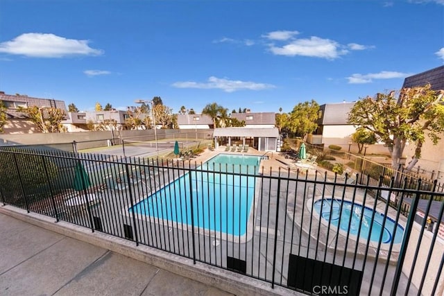 view of swimming pool with a hot tub and a patio