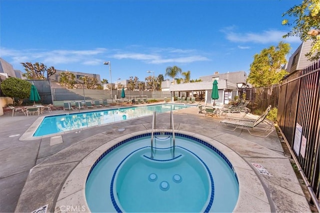 view of pool featuring a hot tub and a patio