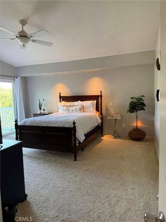 carpeted bedroom featuring access to outside, ceiling fan, vaulted ceiling, and a textured ceiling