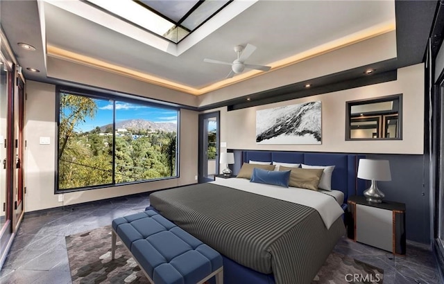 bedroom with ceiling fan and a tray ceiling