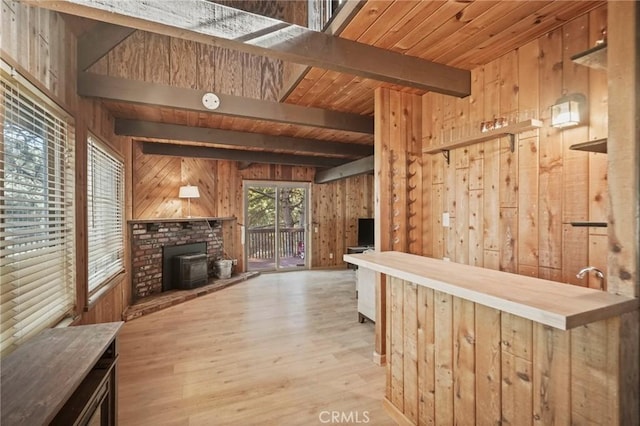 bar with a wood stove, light hardwood / wood-style flooring, and wood walls