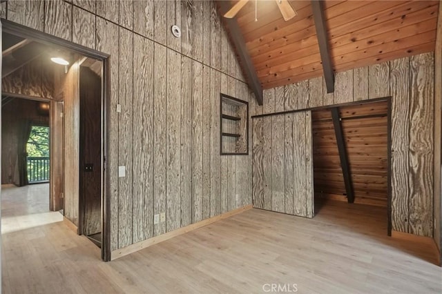 interior space with wood ceiling, wooden walls, ceiling fan, light wood-type flooring, and lofted ceiling with beams