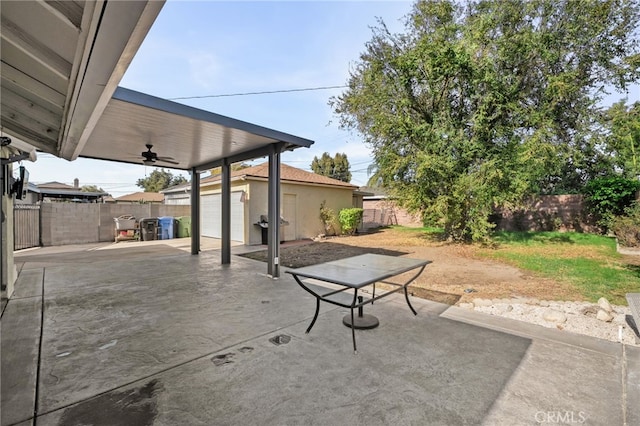 view of patio with ceiling fan, area for grilling, and a shed