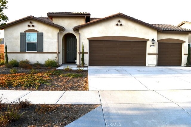 mediterranean / spanish home featuring a garage