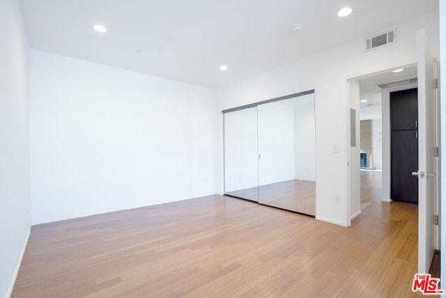 unfurnished bedroom featuring a closet and light hardwood / wood-style floors