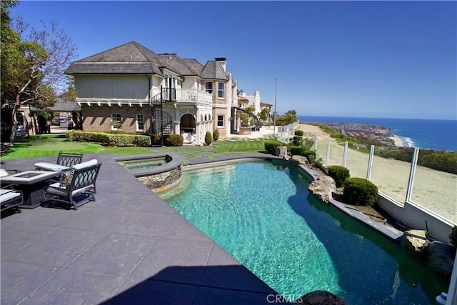 view of pool featuring an in ground hot tub and a water view