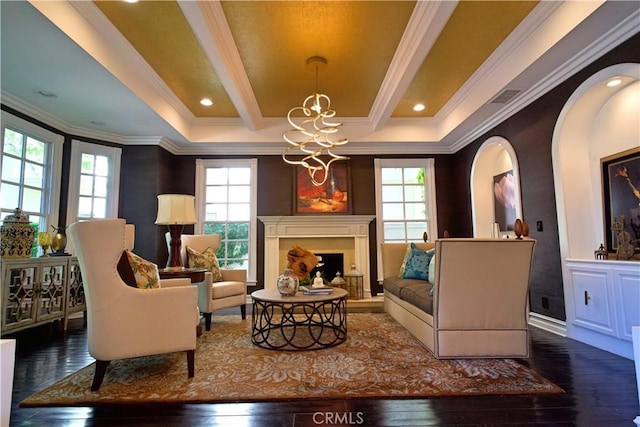 sitting room featuring beamed ceiling, a notable chandelier, dark hardwood / wood-style flooring, and crown molding