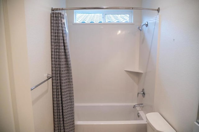 bathroom featuring toilet and shower / bath combination with curtain