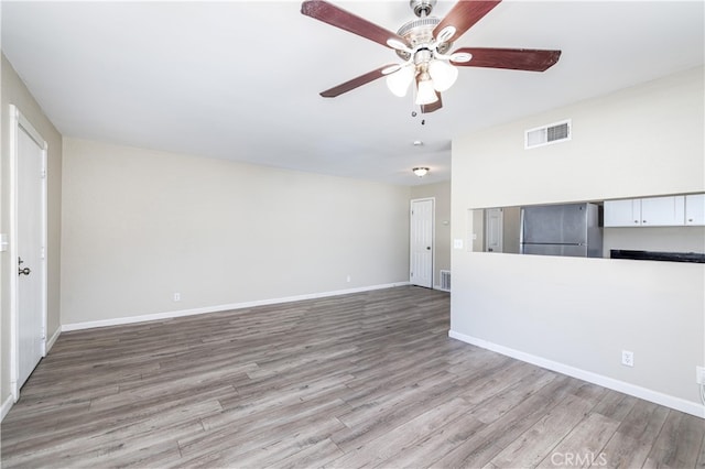 unfurnished living room featuring ceiling fan and light hardwood / wood-style flooring