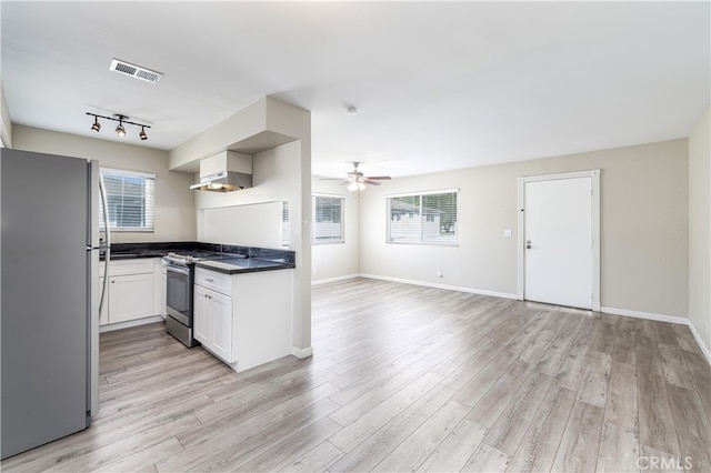 kitchen featuring wall chimney exhaust hood, light hardwood / wood-style flooring, ceiling fan, stainless steel appliances, and white cabinets