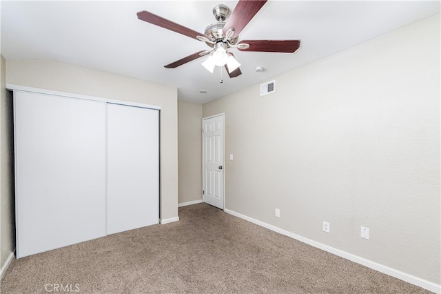 unfurnished bedroom with ceiling fan, carpet, and a closet