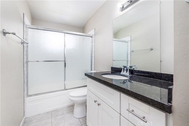 full bathroom with tile patterned flooring, vanity, shower / bath combination with glass door, and toilet