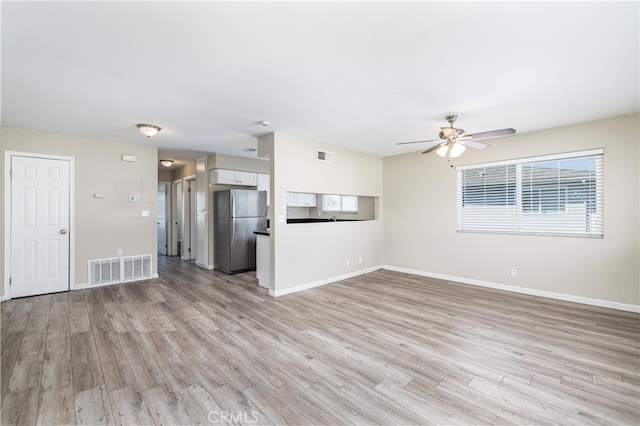 unfurnished living room with light wood-type flooring and ceiling fan