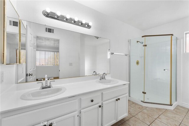 bathroom with tile patterned flooring, a shower with door, and vanity