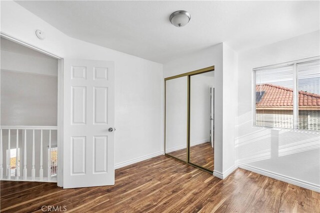 unfurnished bedroom featuring a closet and hardwood / wood-style floors