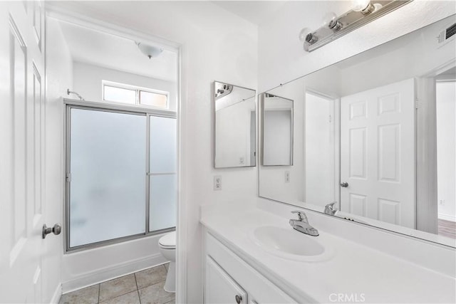 full bathroom with combined bath / shower with glass door, vanity, toilet, and tile patterned flooring