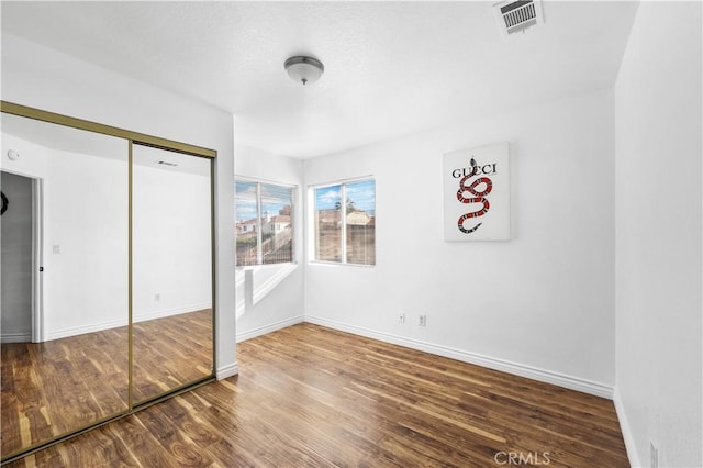 unfurnished bedroom featuring a closet and wood-type flooring