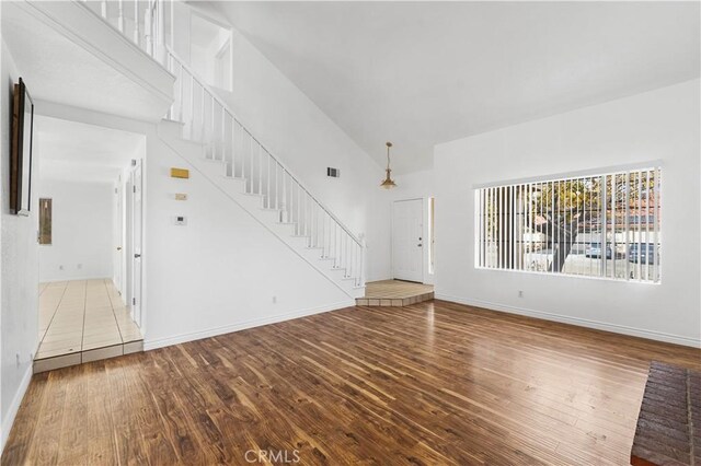 unfurnished living room with hardwood / wood-style flooring and lofted ceiling