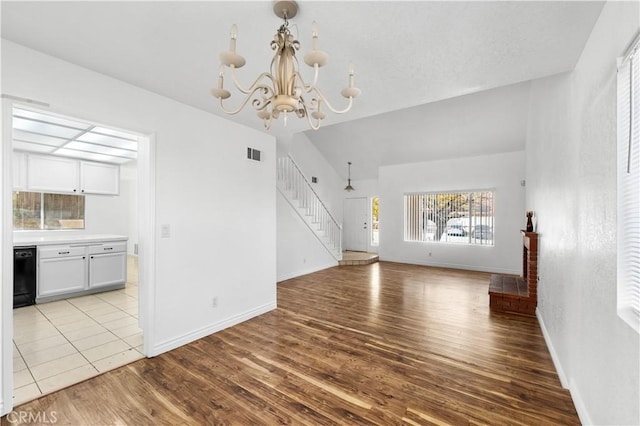 unfurnished living room featuring light hardwood / wood-style flooring and an inviting chandelier