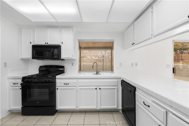 kitchen featuring sink, white cabinetry, black appliances, and a healthy amount of sunlight