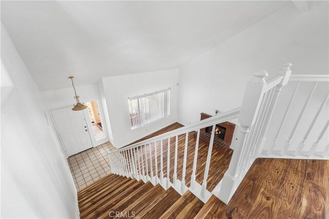 stairs with vaulted ceiling and a fireplace