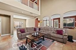 living room with a high ceiling and tile patterned flooring