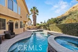 view of swimming pool featuring an in ground hot tub