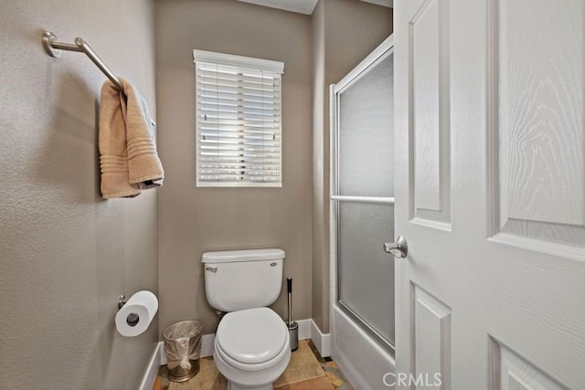 bathroom featuring enclosed tub / shower combo and toilet