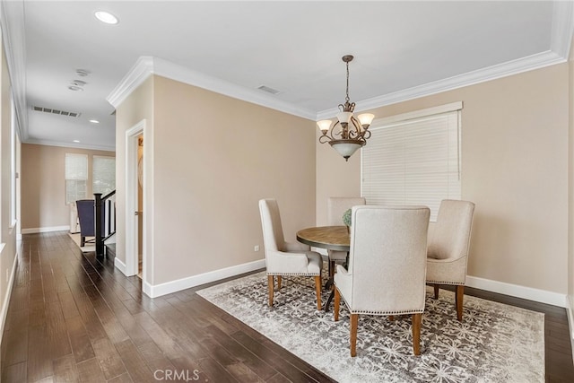 dining room featuring dark wood-type flooring, crown molding, and a chandelier