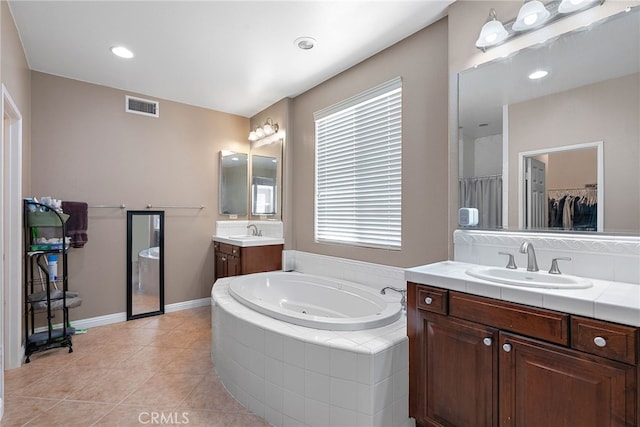 bathroom featuring vanity, tile patterned floors, and tiled tub