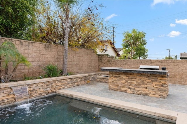 view of pool with a bar, a patio, and area for grilling