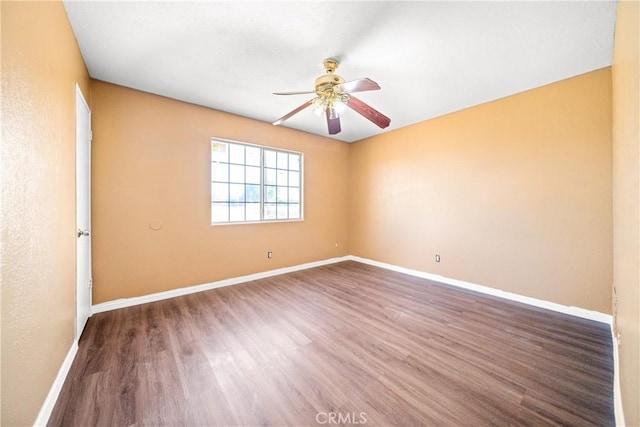 empty room with ceiling fan and dark wood-type flooring