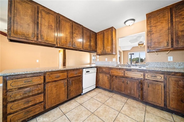 kitchen with sink, kitchen peninsula, light tile patterned flooring, white dishwasher, and light stone counters