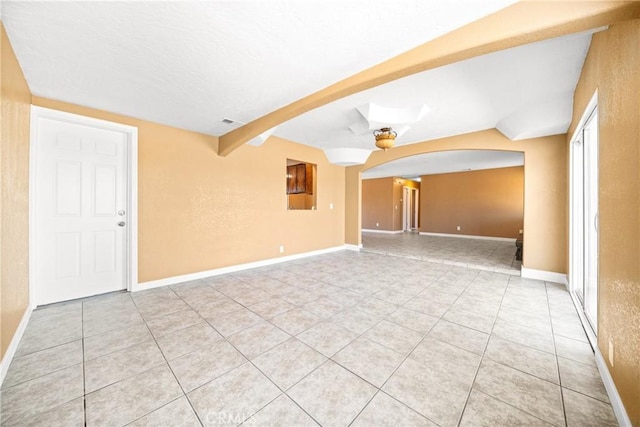 empty room with ceiling fan and light tile patterned floors