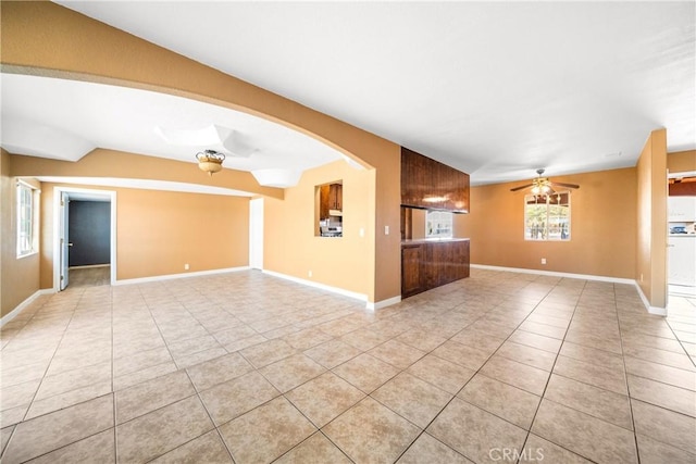 unfurnished living room featuring vaulted ceiling, ceiling fan, and light tile patterned floors