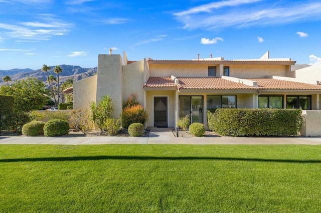 view of front of house with a front yard and a mountain view