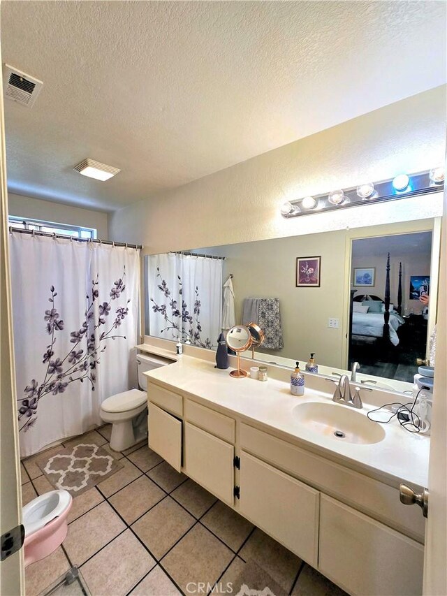 bathroom with toilet, tile patterned floors, a textured ceiling, vanity, and curtained shower