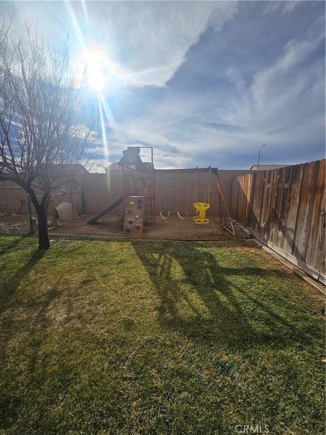 view of yard with a fenced backyard and a playground