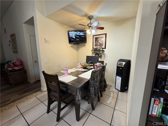 dining area featuring light tile patterned floors, ceiling fan, and baseboards