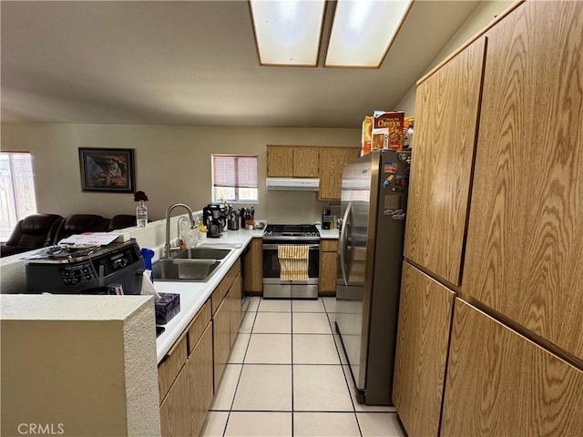 kitchen featuring appliances with stainless steel finishes, plenty of natural light, light tile patterned flooring, and a sink