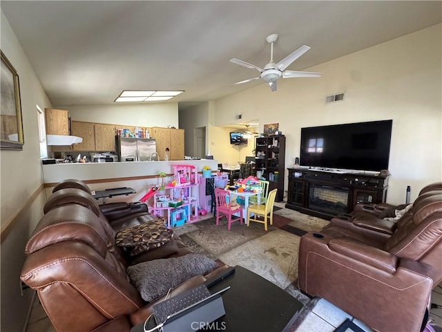 living area featuring visible vents, vaulted ceiling, and a ceiling fan