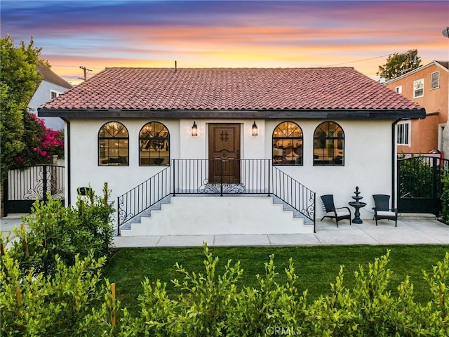 view of front facade with a lawn and a patio area