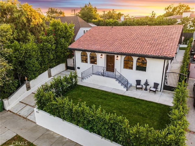 view of front of property with a lawn and a patio area